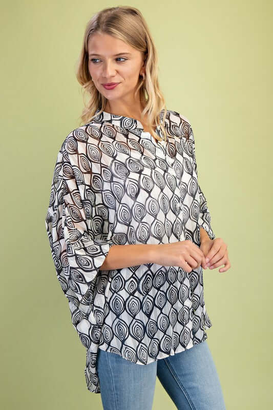 Loose fit sheer lurex button-up top in black and white patterns, featuring hi-low hem, styled with jeans.