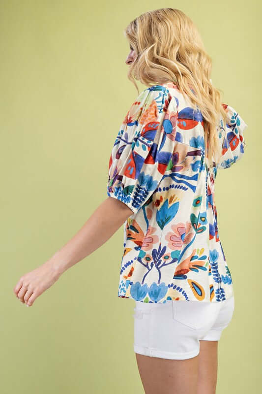 Model wearing colorful Summer Nights Collared Blouse with tie strings, showing vibrant floral print from the back.